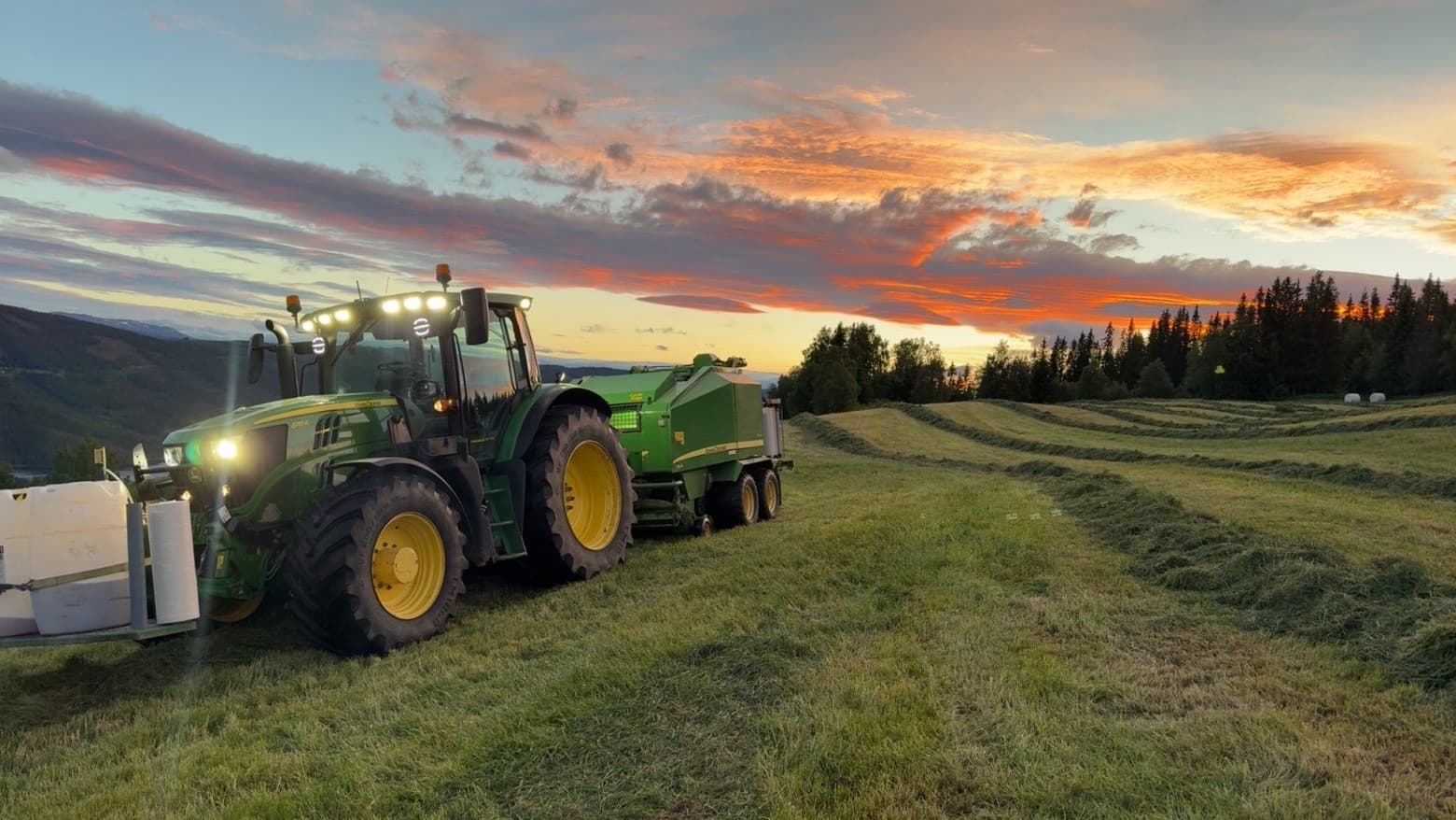John Deere og rundballar i solnedgang i Øystre Slidre